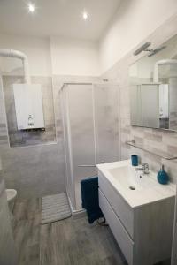 een witte badkamer met een douche en een wastafel bij b&b Tosches in Barletta