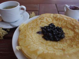 a stack of pancakes on a plate with a cup of coffee at Family Hotel Silver in Smolyan