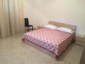 sypialnia z łóżkiem i krzesłem w obiekcie Casa Vacanze Res Publica Domus w mieście Avetrana