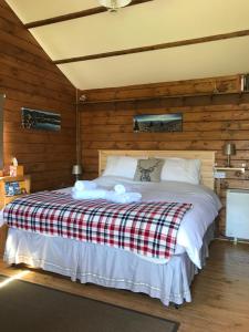 a bedroom with a bed with a red and white blanket at Hill cottage cabins in Fort Augustus