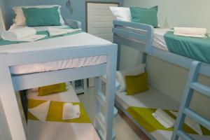 Pokój z 2 łóżkami piętrowymi i drabiną w obiekcie Laule'a Hostel w mieście El Nido