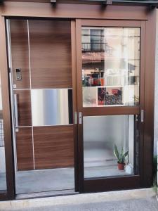 a glass door of a building with a potted plant at Guest House Ringo in Otaru