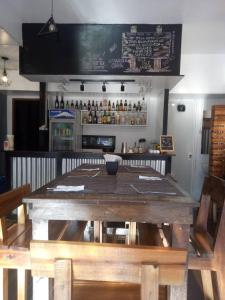 - une table en bois dans un restaurant avec un bar dans l'établissement Laule'a Hostel, à El Nido