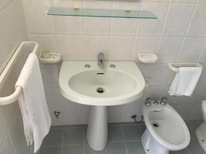 biała łazienka z umywalką i toaletą w obiekcie Casa Vacanze Res Publica Domus w mieście Avetrana +15 zdjęć