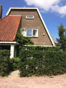 une maison en briques brunes avec un toit rouge dans l'établissement The Livingrooms Laren, à Laren