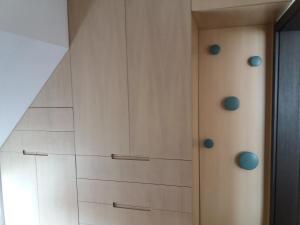 a closet with white cabinets and blue knobs at Bright apartment at a great location in Sofia