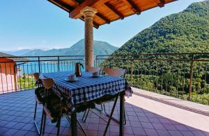 una mesa en un balcón con vistas a las montañas en The Balcony on the Lake en Dizzasco