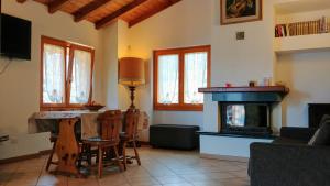a living room with a fireplace and a table and chairs at The Balcony on the Lake in Dizzasco