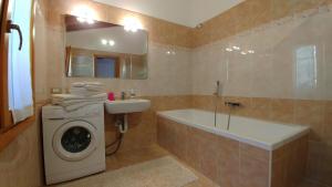 a bathroom with a washing machine and a sink at The Balcony on the Lake in Dizzasco