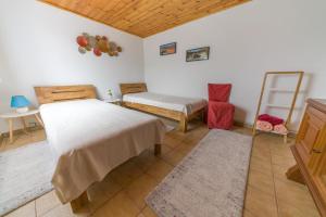 a bedroom with two beds and a table and a mirror at Das Weinberghaus in Ratsch an der Weinstraße