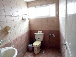 a bathroom with a toilet and a sink and a window at Coastland in Toucheng