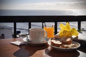 a table with a cup of coffee and bread and a glass of orange juice at Hotel King's in Mar del Plata