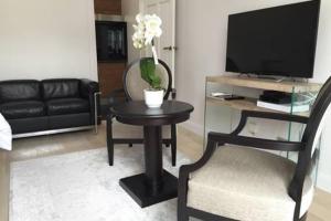 salon ze stołem z krzesłem i telewizorem w obiekcie Appartement Champs Elysées w Paryżu