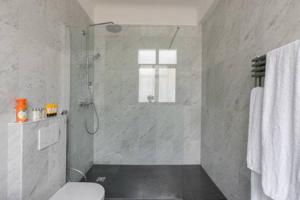biała łazienka z prysznicem i toaletą w obiekcie Appartement Champs Elysées w Paryżu +29 zdjęć