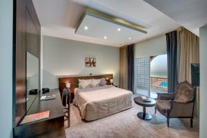 a hotel room with a bed and a balcony at Sharjah Carlton Hotel in Sharjah