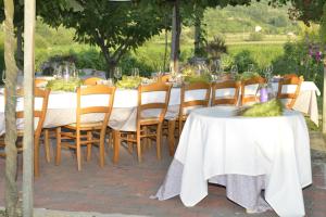 BrendolaにあるLa Pergola Alloggioの白いテーブルクロスと木製の椅子とテーブルサーチャー付きのテーブル