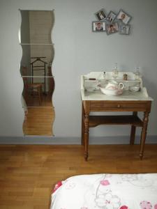 Habitación con mesa, lavabo y espejo. en La Risloise, en Corneville-sur-Risle