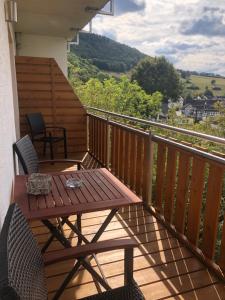 terraza de madera con mesa y sillas en el balcón en Ferienwohnung Ahrblick, en Schuld