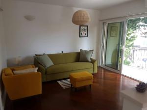 a living room with a green couch and a table at Bright Central Apartman in Tivat