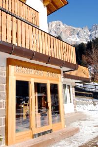 a restaurant with a sign on the front of a building at Residence Adler in San Martino di Castrozza