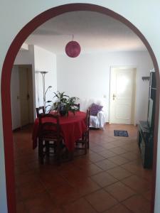 ein Esszimmer mit einem Tisch und einem roten Tischtuch in der Unterkunft Casa Gomikika in São Brás de Alportel