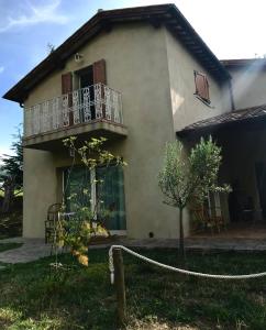 a house with a balcony and a tree at Podere Paradiso in Seggiano