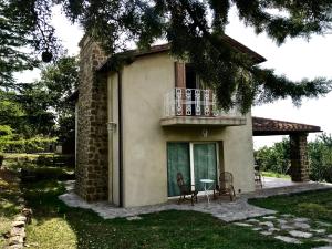 ein Haus mit einem Balkon, einem Tisch und Stühlen in der Unterkunft Podere Paradiso in Seggiano