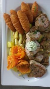 um prato branco de alimentos com carne e produtos hortícolas em Gasthof Polly em Haunoldstein