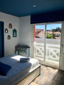sypialnia z łóżkiem i przesuwnymi szklanymi drzwiami w obiekcie La COLOC w mieście Lacanau