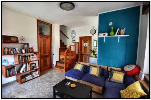 ein Wohnzimmer mit einem Sofa und einer blauen Wand in der Unterkunft WAOBAB - We are one B&B in Alzano Lombardo