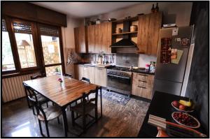 eine Küche mit einem Holztisch und einem Kühlschrank in der Unterkunft WAOBAB - We are one B&B in Alzano Lombardo
