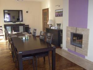 a dining room with a table and a fireplace at Willa Lawenda in Duszniki Zdrój