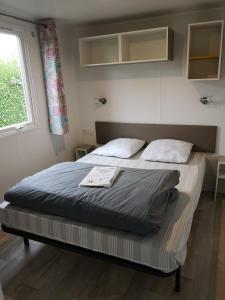 a large bed in a room with a window at Camping Paradis Les Galets de la Molliere in Cayeux-sur-Mer