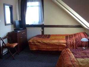 a hotel room with two beds and a television at Willa Lawenda in Duszniki Zdrój