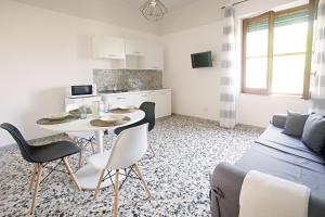 a living room with a couch and a table and chairs at Ciraccio Apartments in Procida