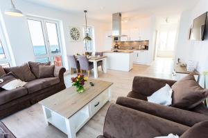 a living room with two couches and a table at Komfort-Ferienwohnung Dat Penthuus by Meer-Ferienwohnungen in Olpenitz