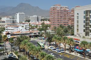a city with cars and palm trees and buildings at eldorado blue in Playa de las Americas