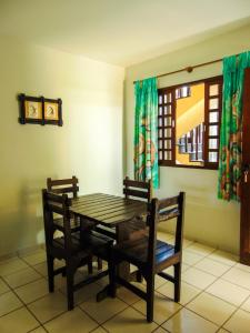 a dining room table with two chairs and a window at Chalés Aguaí in Natal