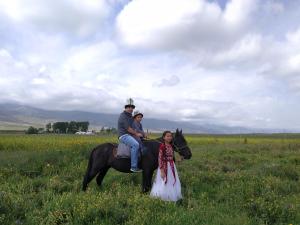 a man and a woman riding a horse in a field at Jaichy Yurt Camp in Këk-Say