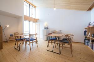 a room with two tables and chairs and a kitchen at Ananda Chillage Yakushima in Yakushima