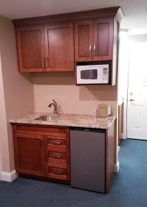 a kitchen with a sink and a microwave at Eastern Inn & Suites (formerly Eastern Inns) in North Conway