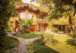 una casa con techo de paja y pasarela en Lake Front Cabin, en Santa Cruz La Laguna