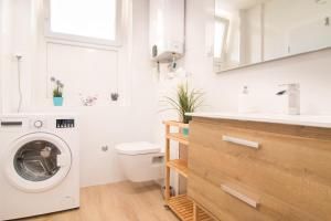 a bathroom with a washing machine and a toilet at Harbour-Apartment with sea view and parking spot in Pula