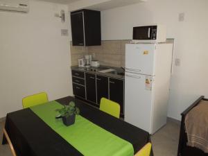 a small kitchen with a refrigerator and a table and chairs at 5 SOLES CHAJARI in Chajarí