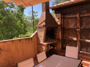 un patio al aire libre con chimenea, mesa y sillas en Casa del Arco, en Casas Altas