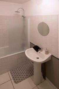 a white bathroom with a sink and a shower at Duplex de charmes n°1 Auxerre. in Auxerre +9 photos