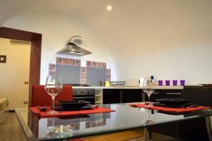 a kitchen with two wine glasses on a glass table at casa del pescatore in Atrani