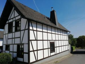 a white and black building with a black roof at Eifel Ferienhaus Luna in Ohlenhard