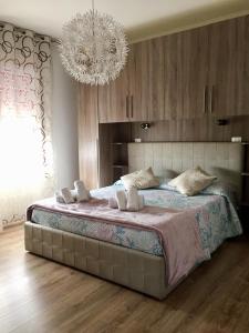 a bedroom with a large bed with a chandelier at Gondola House in Favaro Veneto