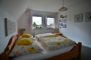 Un dormitorio con dos camas individuales y una ventana. en Ferienhaus Scholien, en Otterndorf